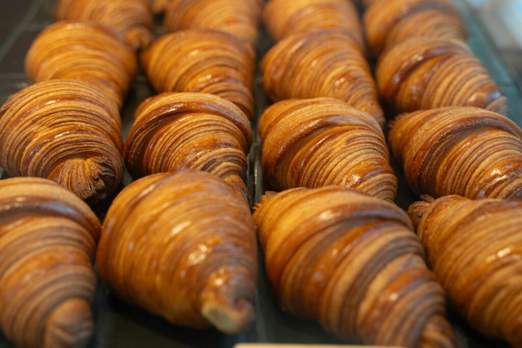 Golden, flaky artisan croissants lined up in a Berlin bakery, perfect morning pastries.